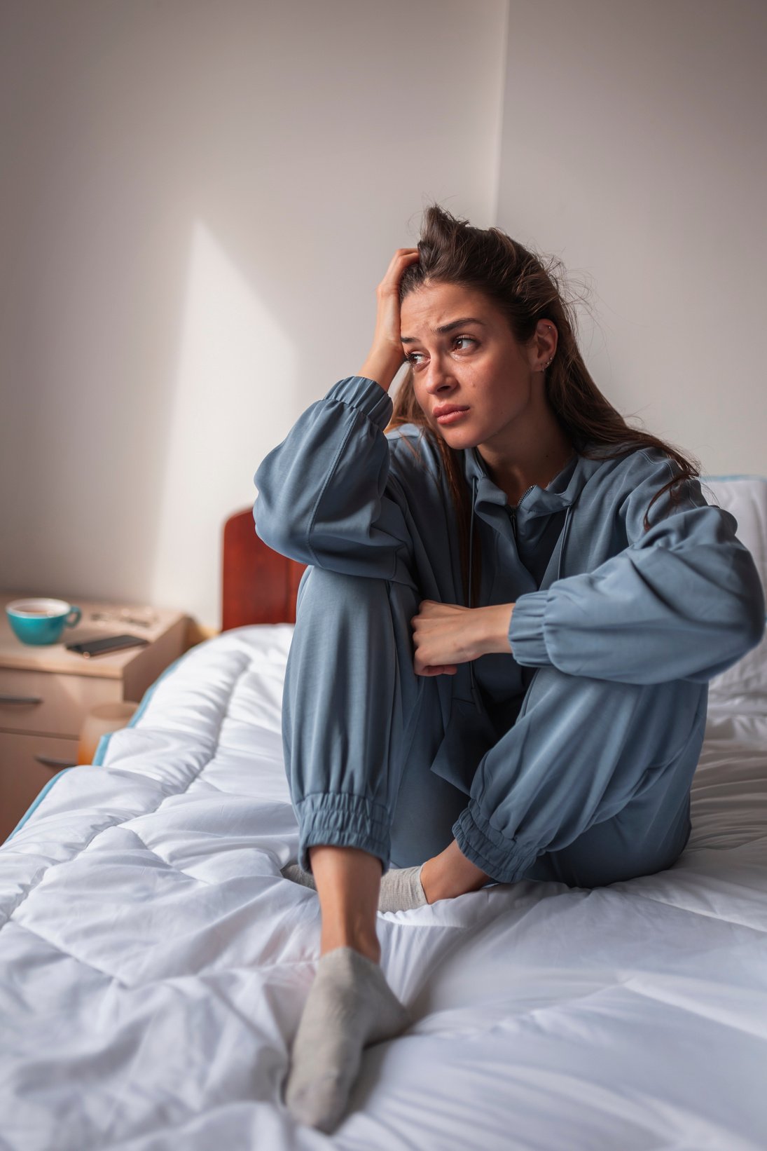 Upset woman sitting in bed